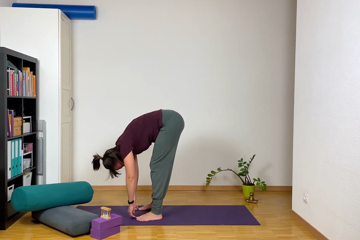 Eine Person praktiziert Yin Yoga und beugt sich anmutig nach vorne.